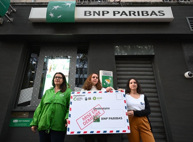 Cécile Duflot, présidente d’Oxfam France, Lorette Philippot, chargée de campagne des Amis de la Terre, et Justine Ripoll, chargée de campagne de Notre affaire à tous, manifestent devant une agence bancaire de BNP Paribas, à Paris, le 26 octobre 2022.